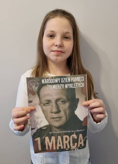 Uczennica prezentująca plakat z majorem Bolesławem Kontrymem ps. "Żmudzin".