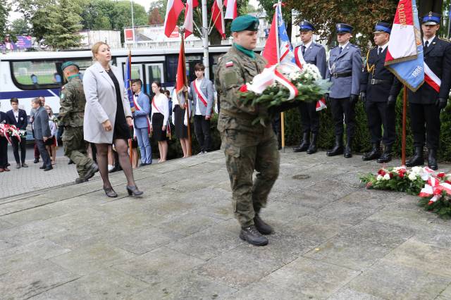 Składanie wiązanek kwiatów pod Pomnikiem Walk i Meczeństwa przez dyrektor biura poselskiego Tadeusza Chrzana-Monikę Romaniec.