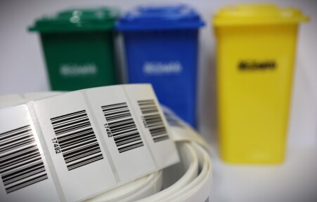 Pilotażowy system kodowania worków na&nbsp;odpady ruszy 1 maja br. - foto etykiet na&nbsp;tle koszy na&nbsp;śmieci