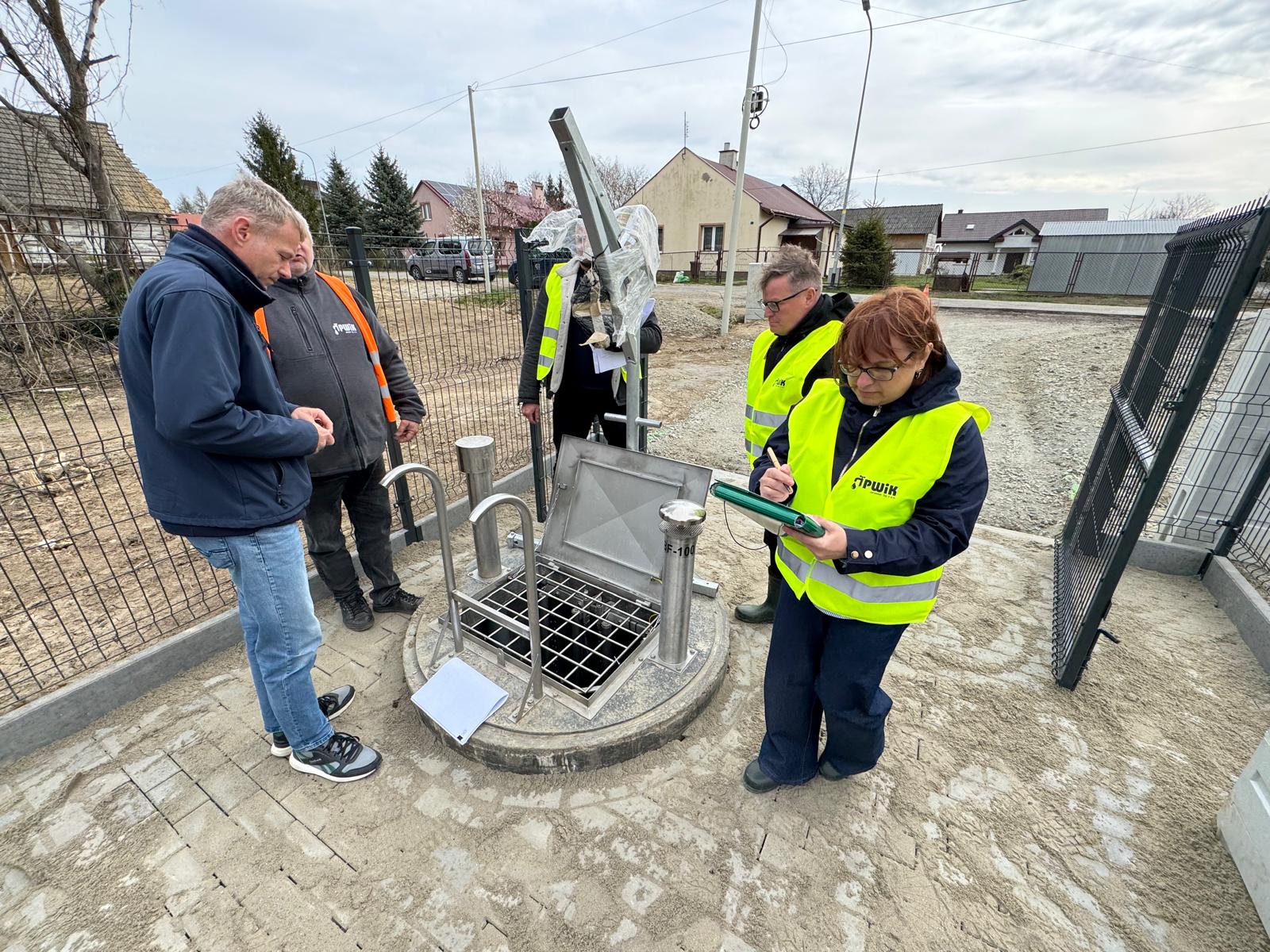 PWiK w&nbsp;Jarosławiu rozpoczął odbiory końcowe inwestycji związanej z&nbsp;budową kanalizacji sanitarnej w&nbsp;ulicach: Dolnoleżajska, Brodowicze i&nbsp;Stawki. Pracownicy w&nbsp;terenie przy urządzeniach.