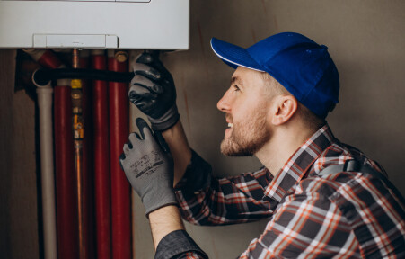 Service man adjusting house heating system - Service man adjusting house heating system