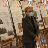Elżbieta Rusinko opowiadająca o wystawie "Skrzydła Pamięci" poświęconej lotnikom z ziemi jarosławskiej w holu JOKiS-u