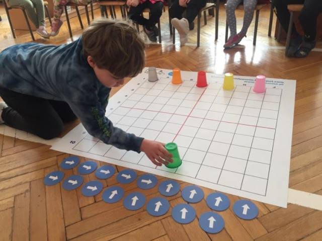 Uczniowie podczas zabawy kolorowymi kubkami uczą się kodowania
