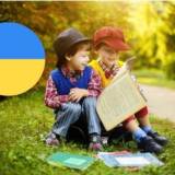 Dzieci czytające książki, z lewej strony barwy Ukrainy w kole- kolor niebieski oraz żółty.