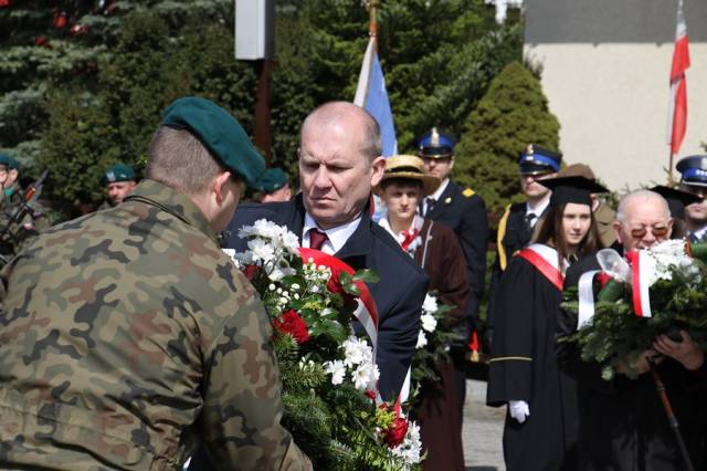 Zastepca burmistrza Dariusz Tracz składa kwiaty pod Pomnikiem Pamięci Narodowej. 