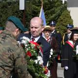 Zastepca burmistrza Dariusz Tracz składa kwiaty pod Pomnikiem Pamięci Narodowej. 